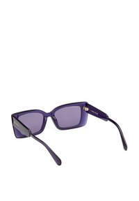 Ochelari de soare purpurii, de formă rectangulară, cu lentile degradate și brațe negre. Prezentând un design geometric îndrăzneț și un logo gravat pe lateral.