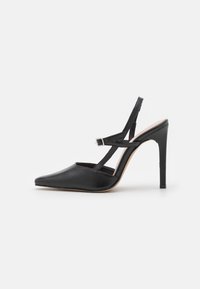Černá kožená vysoká lodička s špičatou špičkou, designem s otevřenou patou, křížovými pásky kolem kotníku a štíhlým jehlovým podpatkem.