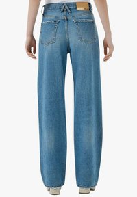 Jeans in denim azzurro chiaro con taglio a gamba larga, vita media, due tasche posteriori e una piccola patch in pelle con il logo sulla cintura.