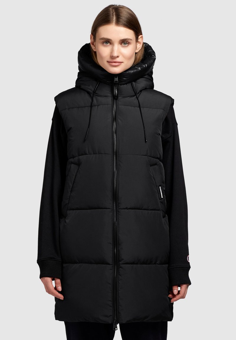 Schwarze Pufferweste mit hohem Kragen und verstellbarem Kapuzen. Verfügt über einen Reißverschluss, gepolsterte Bereiche und seitliche Taschen für Funktionalität.