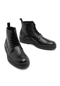 Czarne skórzane buty za kostkę z sznurowadłami, bocznym zamkiem błyskawicznym i grubą gumową podeszwą. Gładka tekstura bez wyraźnych wzorów czy akcentów.