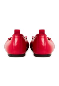 Ballerine in pelle rossa con una texture liscia e forma arrotondata. Presentano un dettaglio a fiocco sulla parte anteriore e una suola nera.