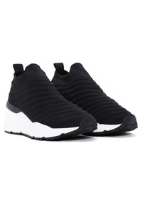 Black slip-on knit sneakers with white chunky soles and black pull tabs at the heel, designed for casual wear.