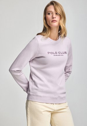 Lichtpaarse sweatshirt met ronde hals, geribbelde manchetten en onderrand. Op de voorkant staat in donkerpaarse tekst "POLO CLUB OPGERICHT 2012."