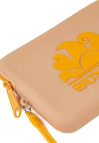 Clutch in silicone color pesca con un design del sole giallo in rilievo, dotato di una cerniera con un tirante giallo e una superficie testurizzata.