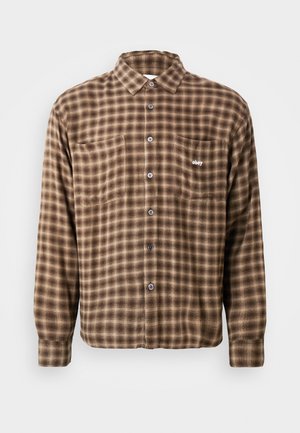 Brown plaid shirt made of soft fabric, featuring a button-up design, two chest pockets, and an embroidered logo on the left pocket.