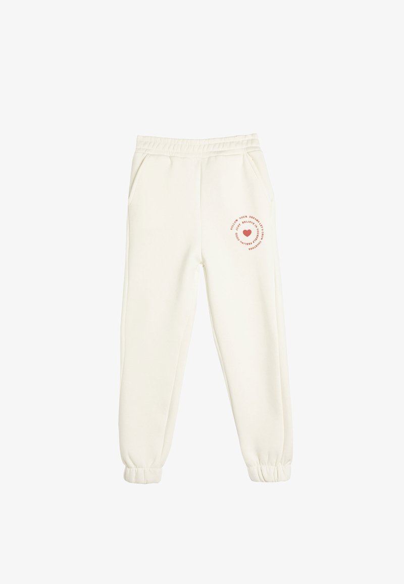 Cremefarvede sweatpants lavet af blødt stof. Har elastisk talje, sidelommer og et trykt design med et hjerte på venstre ben.