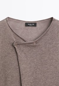 Maglione marrone lavorato a maglia con scollatura rotonda e una piccola chiusura a bottone vicino al collo, etichetta che legge "Massimo Dutti Made in China".