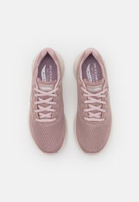 Sneakers da atletica di colore rosa chiaro con una tomaia in mesh traspirante, punta rotonda, lacci e suola ammortizzata. Presenta logo sul lato e linguetta imbottita.