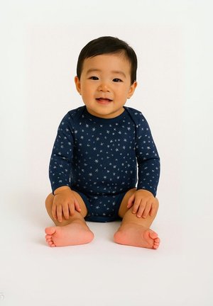 Mornarska bodysuit s dolgimi rokavi z belim vzorcem zvezd, iz mehkega materiala in oprijetega kroja, na otroku, ki sedi z golo nogami na nevtralni podlagi.