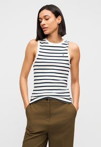 Μπλε ναυτικό και λευκό ριγέ αμάνικο τοπ με στρογγυλή λαιμόκοψη, συνδυασμένο με ψηλόμεσο παντελόνι σε ελιά πράσινο χρώμα που διαθέτει πλαϊνή τσέπη.