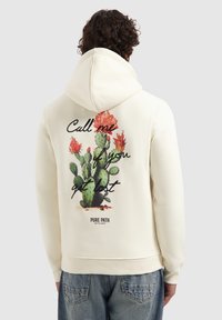Crème hoodie met een cactusgrafiek en tekst op de rug. Heeft een trekkoordcapuchon en ribgebreide manchetten. Casual ontwerp geschikt voor dagelijks gebruik.
