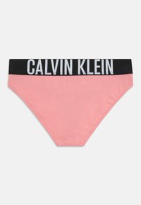 Rózsaszín női bikini alsó széles fekete derékpánttal, amelyen a fehér Calvin Klein logó látható.