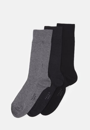 Tre par strumpor i mörkgrått, kolgrått och svart. De är tillverkade av ett mjukt, slätt material med en enkel design och ribbade muddar.