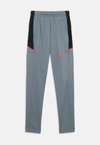 Grijze sportbroek met zwarte zijpanelen en oranje Nike-swoosh op de linkerdij, elastische tailleband en zijzakken.