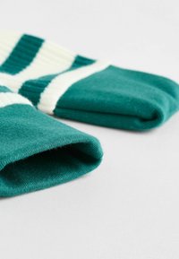Teal and white striped knit socks, featuring a ribbed texture and a rolled cuff design. Soft material with a smooth finish.