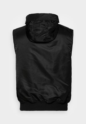 Must toomata, ilma varrukat puffer vest kõrge krae ja elastse ribaga, vaadatud seljalt heledal taustal.