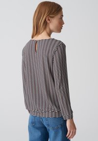 Lange mouw blouse in een lichte, gebloemde stof met horizontale strepen in bruin, crèmekleur en marineblauw. Inclusief een keyhole-detail op de rug.
