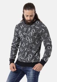 Zwarte sweatshirt met witte letterprint, ronde hals en ribgebreide boorden en zoom. Op de torso is een klein logo label zichtbaar.