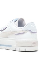 Sneaker bianchi con suola spessa, con accenti in suede beige e viola chiaro, dettagli testurizzati e una striscia blu a contrasto.