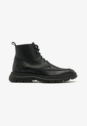 Schwarze Leder-Ankle Boots mit strukturiertem Finish, runder Zehenpartie, sechs Ösen Schnürdesign und einer robusten Gummisohle für guten Halt.