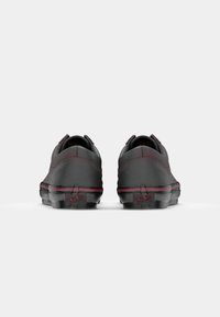 Chaussures en cuir noir avec un profil bas, un bout rond et des accents de couture bordeaux. Présentent une semelle en caoutchouc texturé et un détail de logo sur le talon.