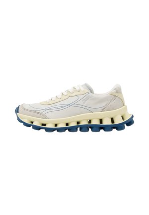 Hvid og beige sneaker med blå accenter, snørebånd, buede syninger og en unik segmenteret sål i creme og mørkeblå farver.