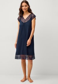 Camicia da notte blu navy realizzata in tessuto morbido con bordi in pizzo alle maniche e all'orlo, caratterizzata da una vestibilità comoda e scollatura a V per il massimo comfort.