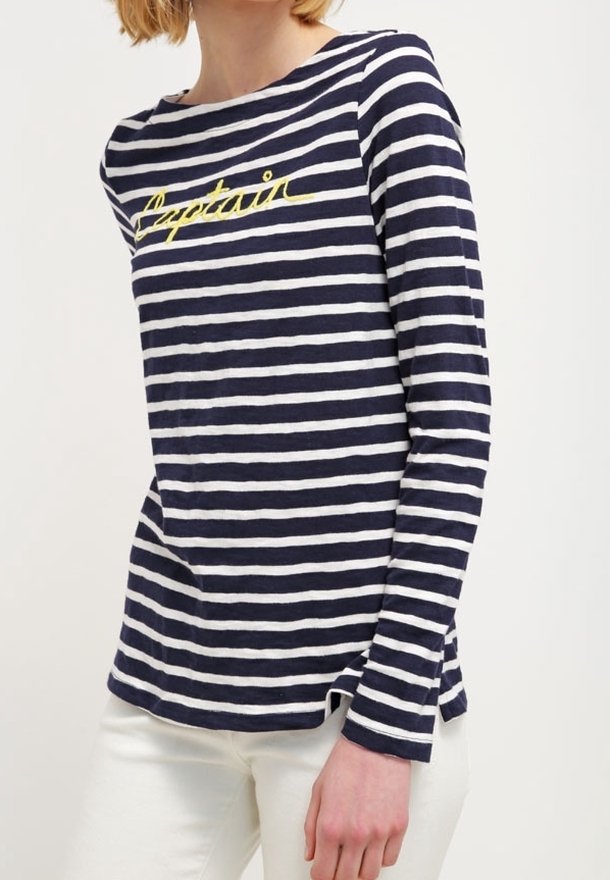Marineblaue und weiße gestreifte Langarmbluse mit rundem Ausschnitt. Mit gelbem "Captain"-Text auf der Vorderseite und seitlichen Schlitzen am Saum.