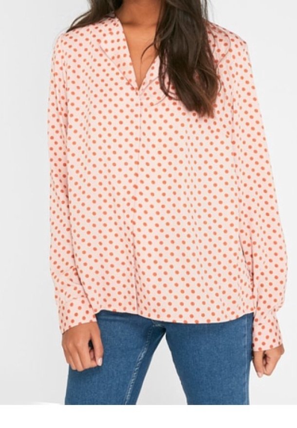 Blusa a maniche lunghe con sfondo rosa e pois arancioni, design a scollatura a V, tessuto morbido e vestibilità comoda.