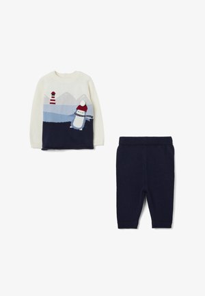 Completo in maglia composto da un maglione crema con motivo pinguino, dettagli blu navy e pantaloni coordinati blu navy con elastico in vita.