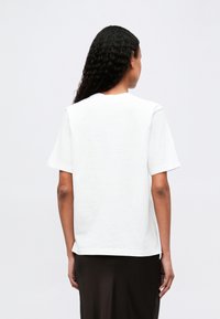 White cotton T-shirt with short sleeves, crew neck, and a straight cut, featuring a smooth texture and no visible patterns or accents.