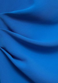 Tela azul con una textura suave, con suaves pliegues y drapeados. El color es vibrante y uniforme, mostrando un tono azul rico y profundo.