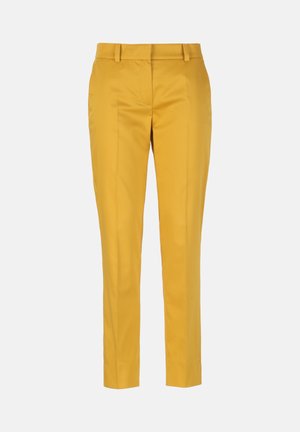 Pantaloni gialli su misura con passanti per cintura, piega frontale e vestibilità slim alla caviglia su uno sfondo grigio chiaro uniforme.