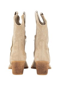 Botas de tobillo de ante color beige con tacón de bloque, que presentan patrones de costura intrincados y cremalleras laterales para una fácil puesta.