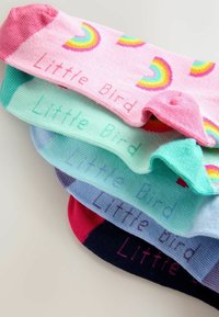 Calcetines coloridos en una pila: rosa con arcoíris, verde menta, azul claro y marino, todos con "Pajarito" impreso en colores a juego.