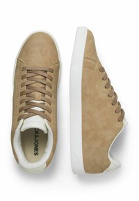 Beige Sneakers aus Kunstleder mit weißen Sohlen, ausgestattet mit flachen Schnürsenkeln, gepolstertem Zunge und einer strukturierten Ferse. Klassisches, niedriges Design.