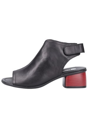 Czarne skórzane sandały typu slingback z odkrytymi palcami, z czerwonym blokowym obcasem i paskiem na rzep do regulacji. Gładka tekstura z minimalnymi detalami.