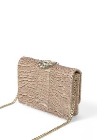 Bolso de mano beige texturizado con cadena, que presenta un cierre decorativo de gema y un patrón de superficie ondulado.
