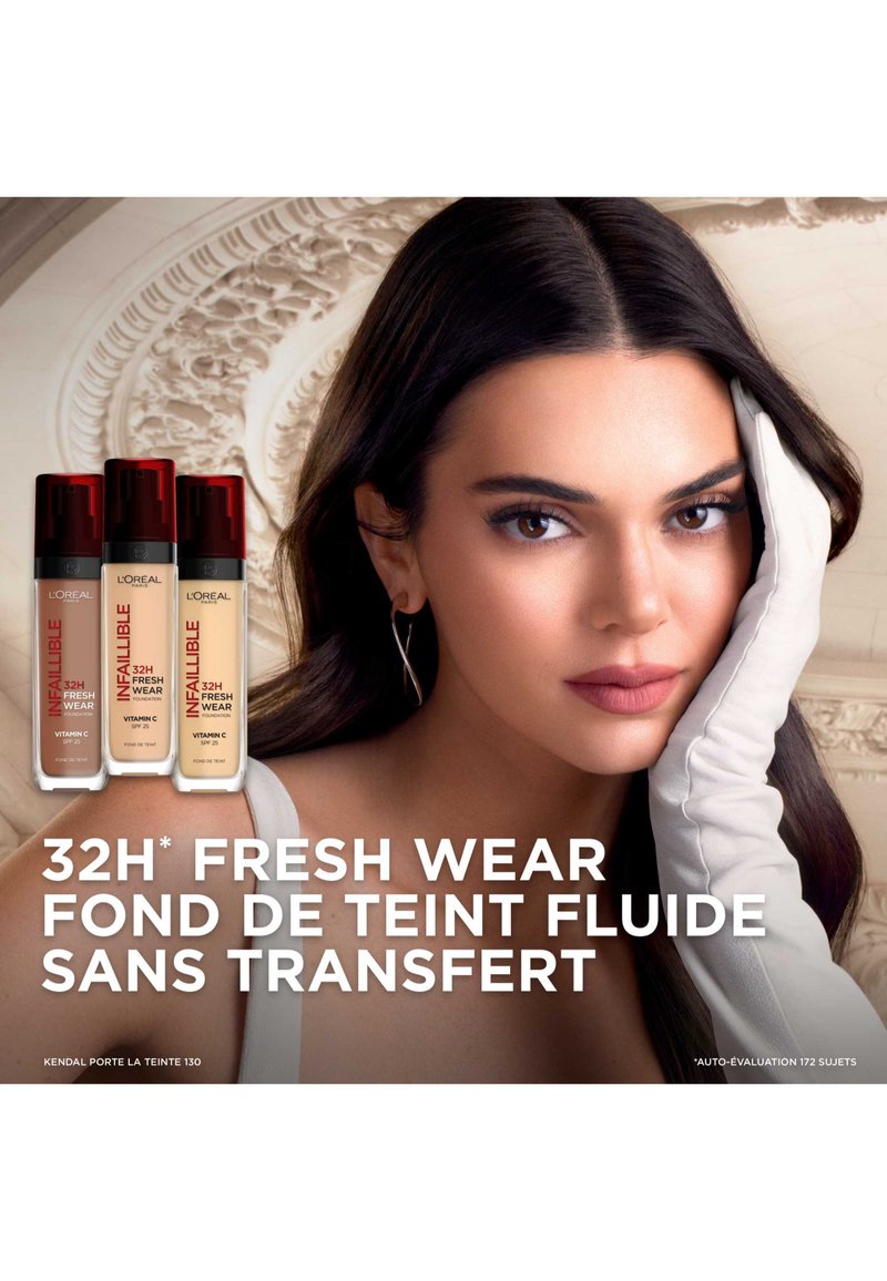 Bouteilles de fond de teint L'Oréal Infallible 32H Fresh Wear avec des bouchons rouges en différentes nuances, présentées aux côtés d'un modèle avec une peau lisse et claire portant des gants.