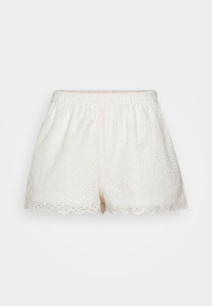 Baltas izšūtas bikses ar viļņotu apakšmalu, kas rotātas ar ziedu rakstu un elastīgu vidukli ērtībai.