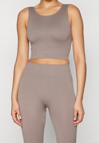 Light taupe ribbed crop top paired with matching high-waisted leggings, featuring a soft texture and a fitted design for a streamlined silhouette.