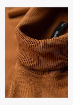 Brauner Strickpullover mit Stehkragen. Glatte Textur mit feinen Nähdetails und einem sichtbaren Markenlabel im Nacken.