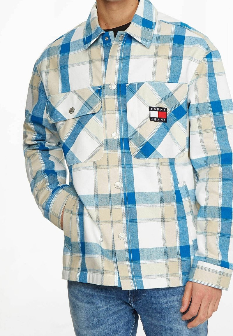 Blå och beige rutiga skjorta i bomull, med två framfickor, krage med knappar och en logotäpp på vänster bröst.