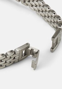 Bracelet de montre en métal avec une finition argentée brossée, des maillons entrelacés et un fermoir à charnière sécurisé avec des vis visibles.