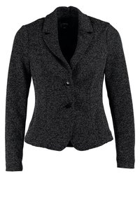 Veste en tweed noir et blanc à coupe ajustée, avec revers crantés et une fermeture à un bouton noir. Manches longues et texture lisse.