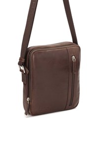 Bolsa mensajera de cuero marrón con una textura suave, bolsillo frontal con cremallera y una correa ajustable. Presenta un detalle sutil del logo y líneas limpias.