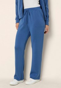 Blue sweatpants made of soft fabric, featuring an elastic waistband with a drawstring, side pockets, and a straight leg design.