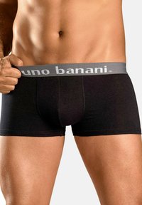 Crne bokserice sivoj gumici s logotipom 'bruno banani'. Izrađene od glatkog materijala, uzani kroj i dužina do sredine bedara.
