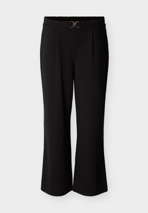 Mustat housut, joissa rento istuvuus, tasainen vyötärönauha ja kullanvärinen koriste edessä. Sileä kangas ja laskokset.